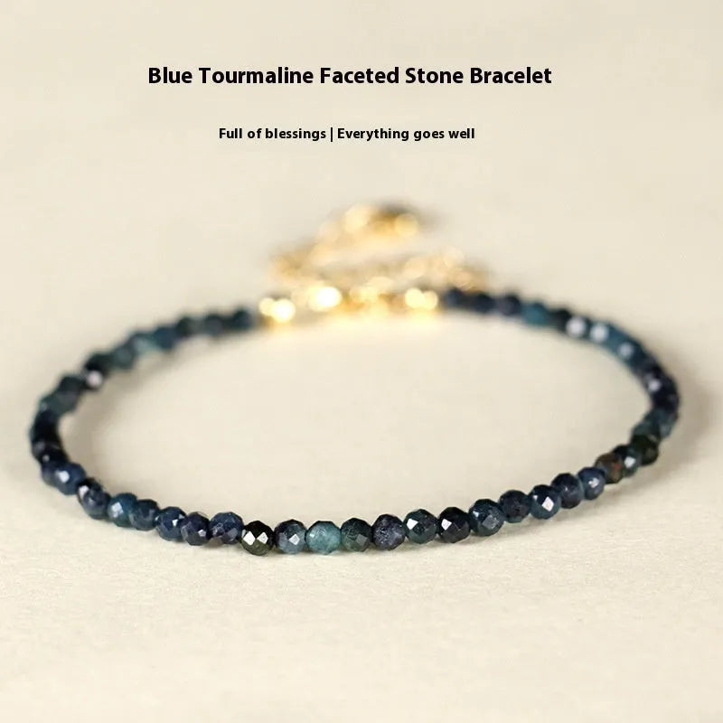 Blue tourmaline gemstone bracelet with 3mm cut beads on a white background.