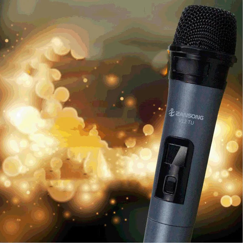 Black handheld dynamic microphone with USB receiver and cables on a table.