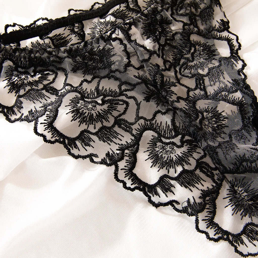 Black women's lace bikini lingerie set with steel ring details and adjustable straps.