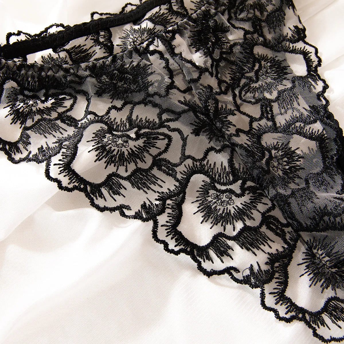 Black women's lace bikini lingerie set with steel ring details and adjustable straps.