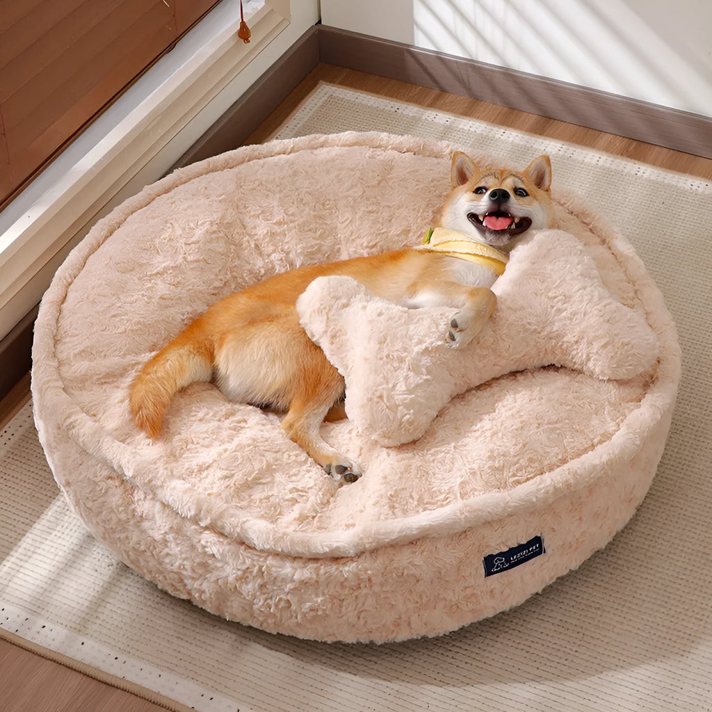 Small milk tea coloured fabric dog kennel with a round nest design on a wooden floor.