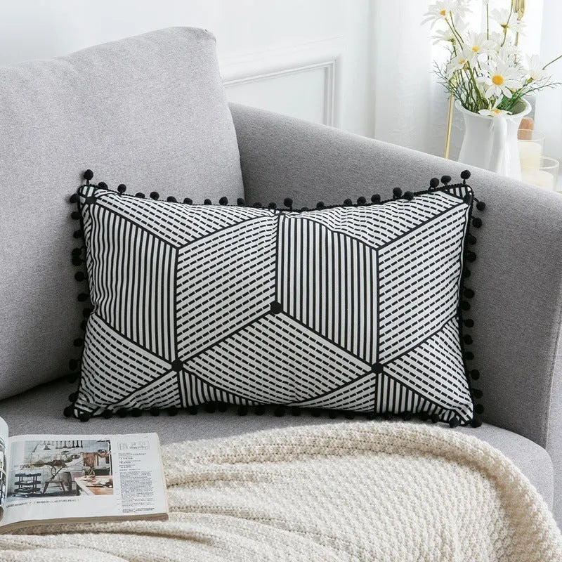 Bohemian style decorative throw pillow with polyester cover in light grey on a sofa.