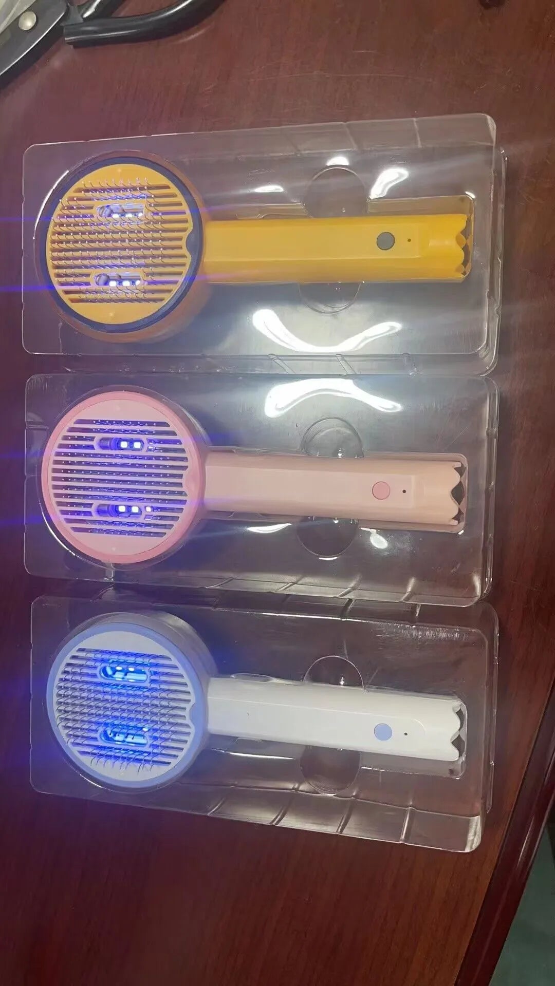 USB rechargeable UV sterilization pet comb for cats and dogs in pink, yellow, and white ABS plastic