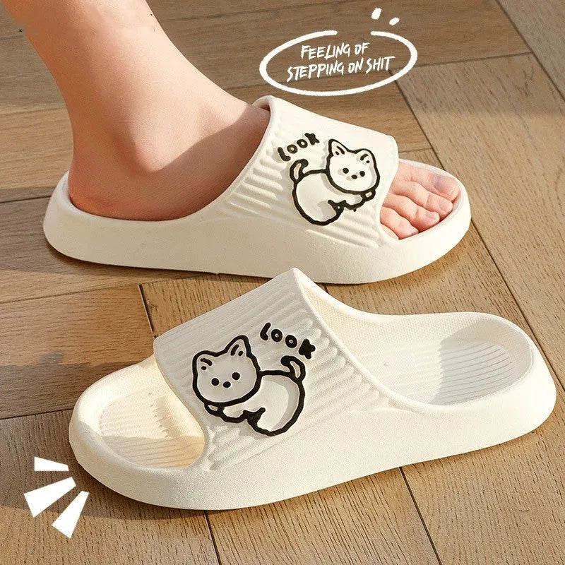 Women's pink EVA cat slippers with thick platform sole on a wooden floor.