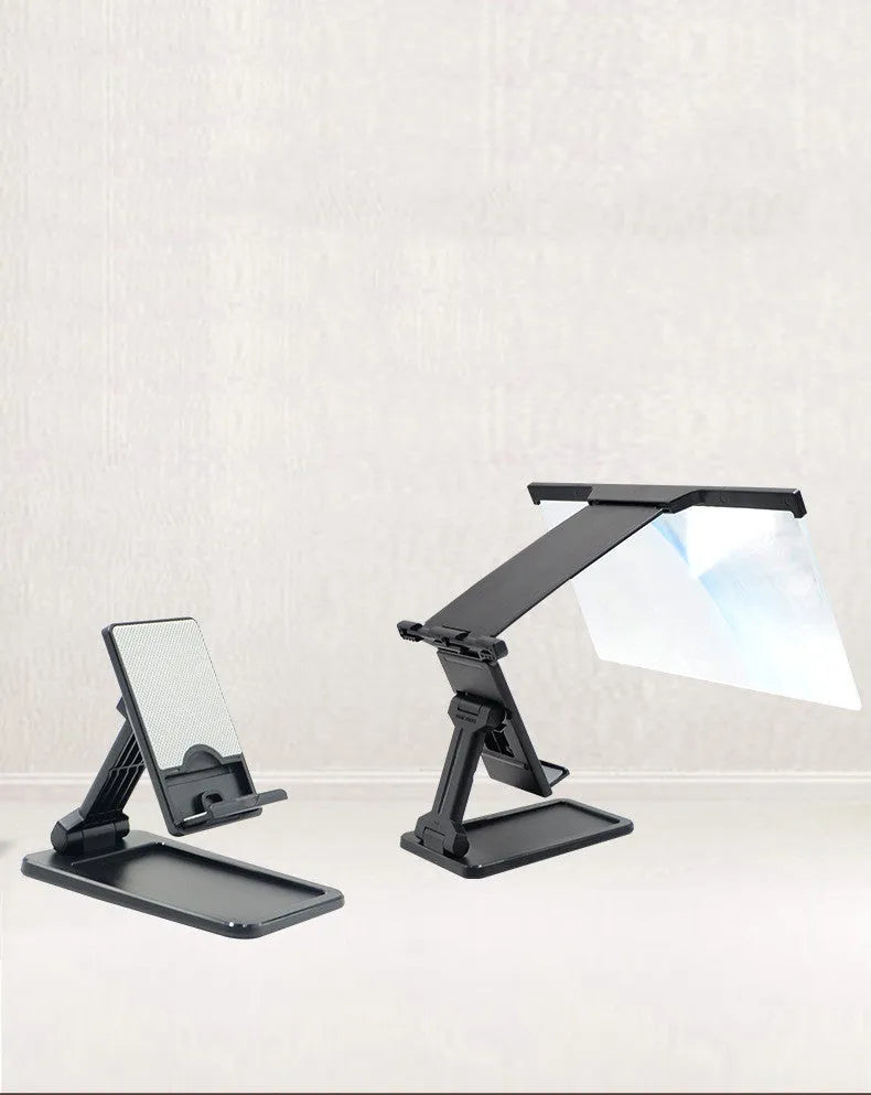 Black folding mobile phone screen magnifier and detachable phone holder on a desk.