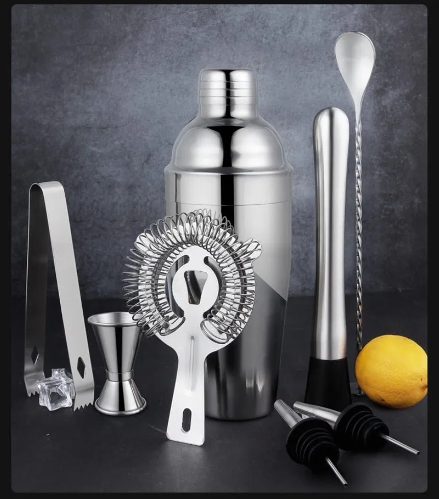 23-piece stainless steel and acrylic cocktail set with shakers, jiggers, and bar tools on a counter.