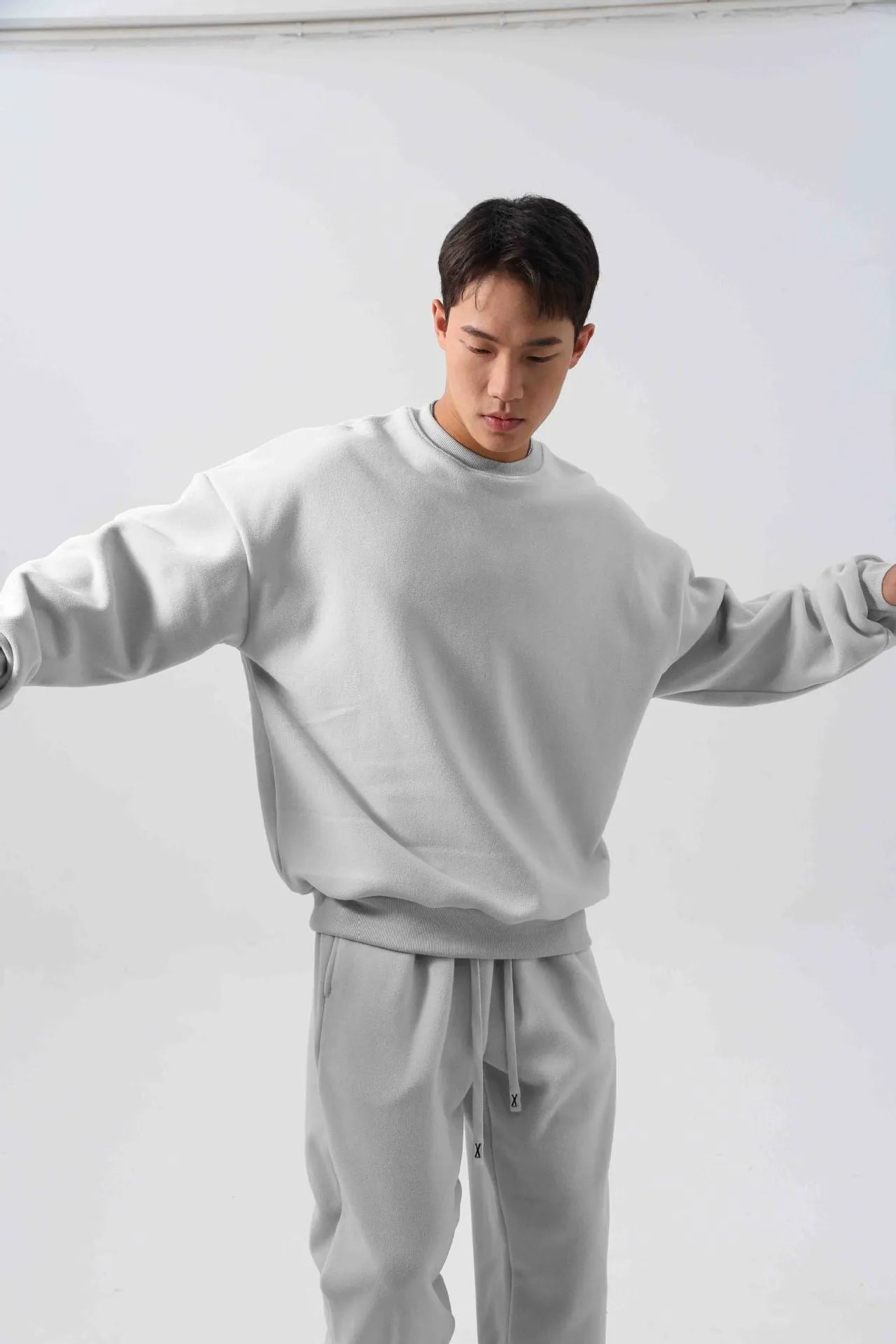 Man wearing a loose black polar fleece winter sports suit with crew neck coat and trousers