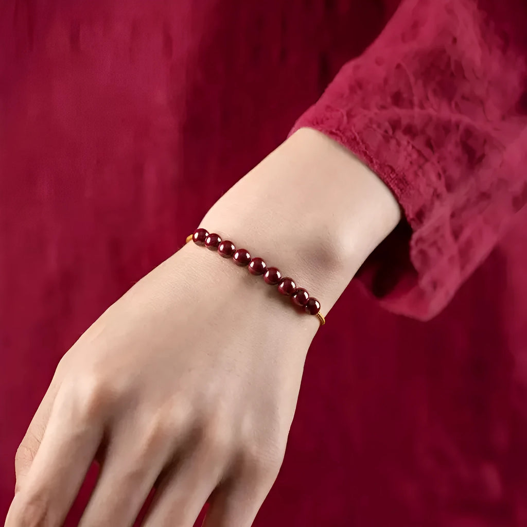Hand-woven cinnabar and Hetian jade geometric bracelet on wrist showing natural stone textures
