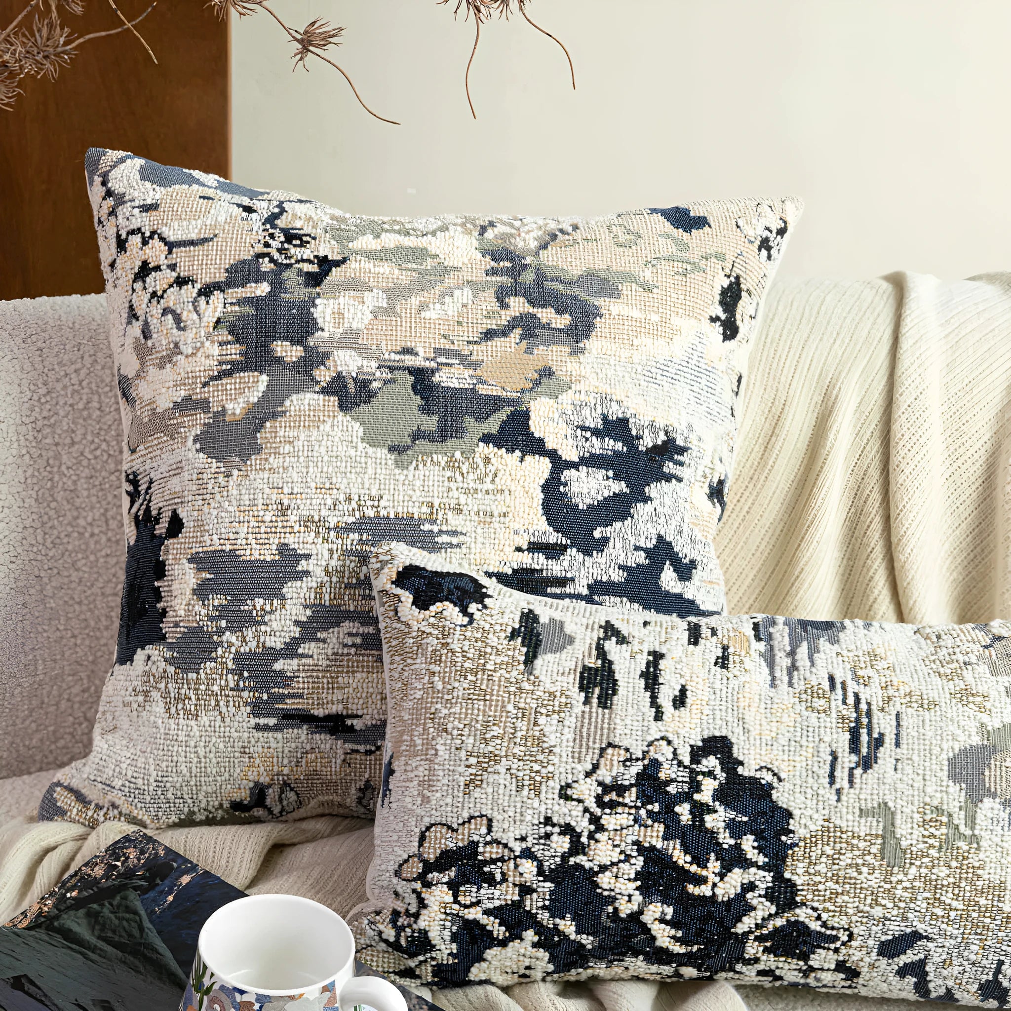Blue floral antique pattern wool blend cushion cover and feather velvet pillow on a sofa.