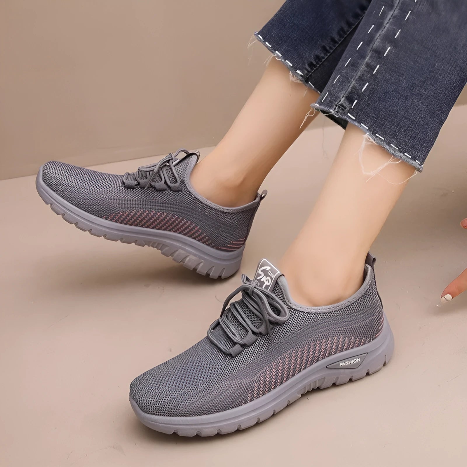 Women's black mesh sneakers with cross-strap detail and round toe on a rubber sole.