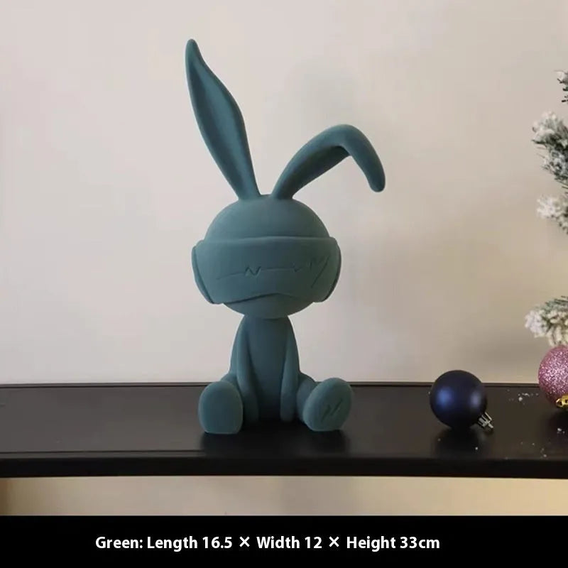 Green suede-finish resin ornament of a blindfolded rabbit for table decoration.