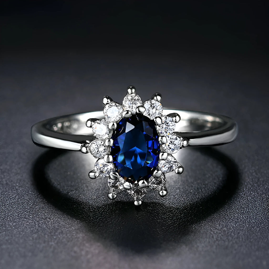 Copper floral women's ring with inlaid zirconia stone in green, blue, or red colour on a white background.