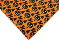 Reversible Halloween dog bandana showing pumpkin design on one side and spider web pattern on the other