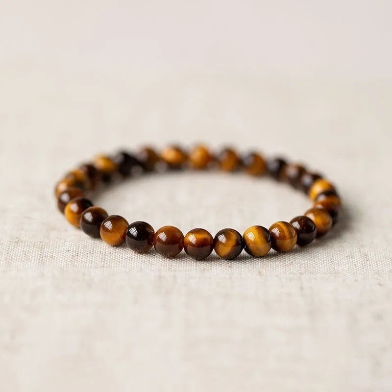 Single circle ethnic Tigereye bead Buddha rosary bracelet on a wrist, showing unisex design.