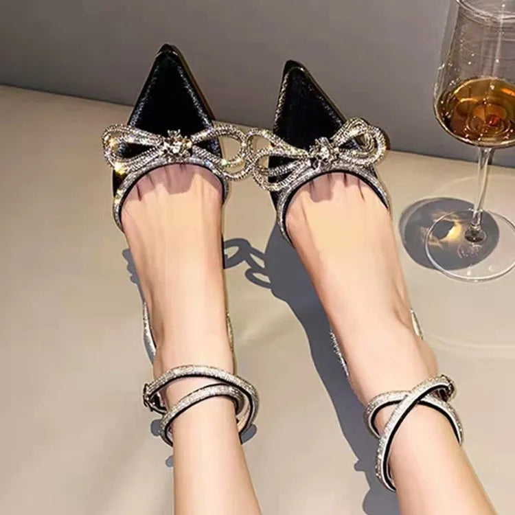 Women's black stiletto heel sandals with a silk back bandage and pointed toe on a white background.