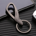 Black zinc alloy keychain with two split rings and a waist clip, shown next to a car key for scale.