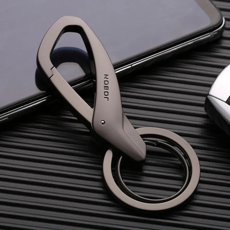 Black zinc alloy keychain with two split rings and a waist clip, shown next to a car key for scale.