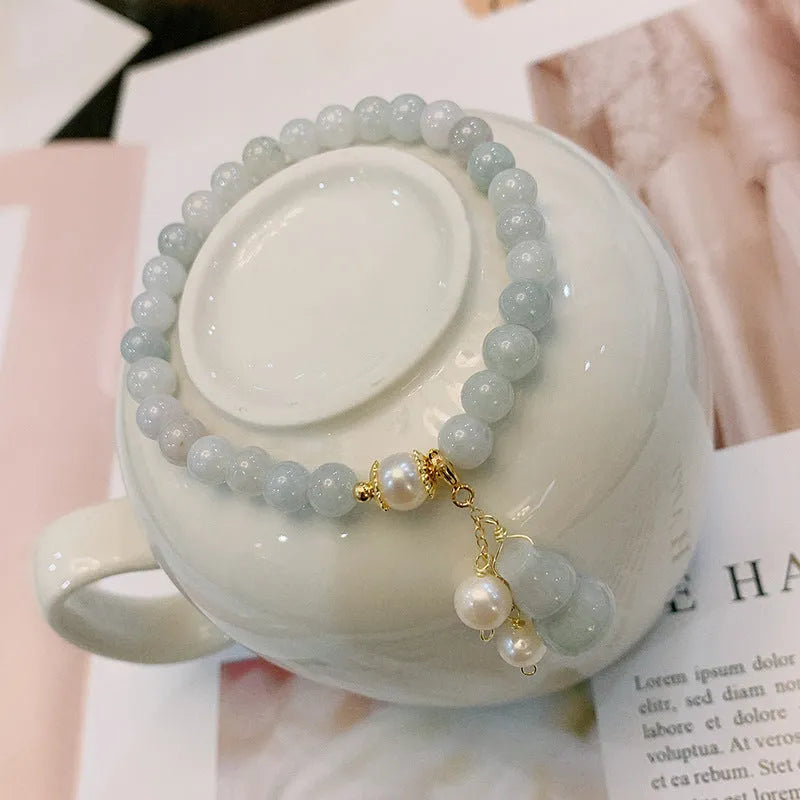 Traditional Chinese style jade bracelet with raised gourd design and pearl accents on green stone