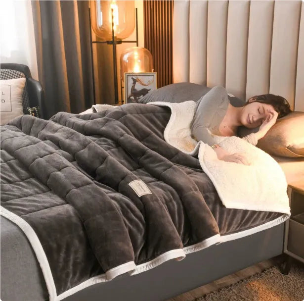 Thick coral fleece winter blanket in a solid colour, shown on a bed, dimensions 150cm by 200cm.