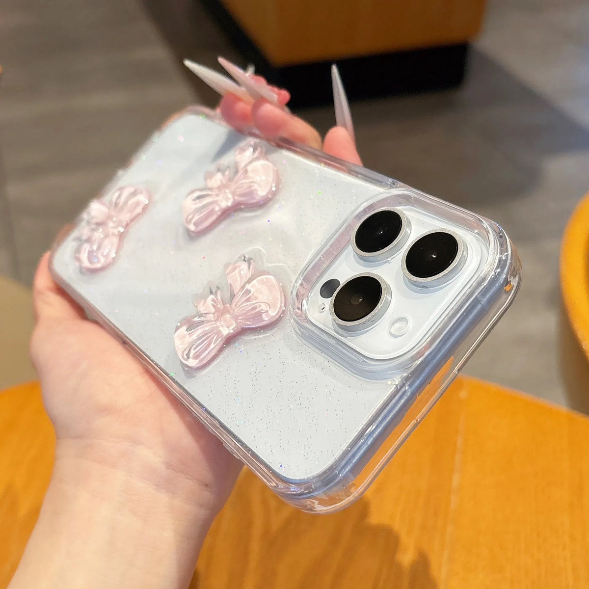 Transparent silicone iPhone case with pink bow knot and clear drop-resistant cover.