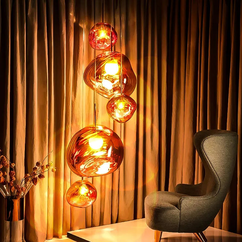 A modern irregular shaped glass chandelier with a Nordic design in a gold finish, hanging from a ceiling.