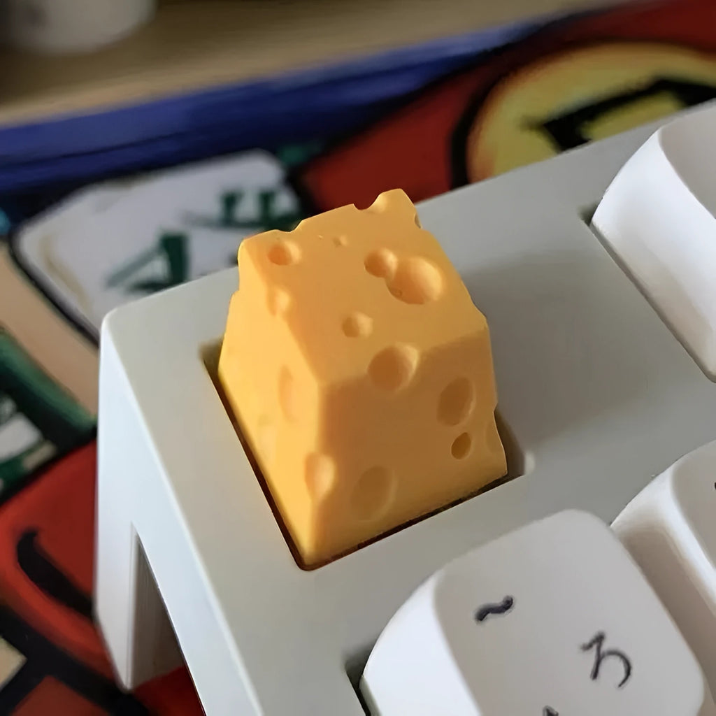 Yellow resin cheese character key cap for mechanical keyboards on a white background.