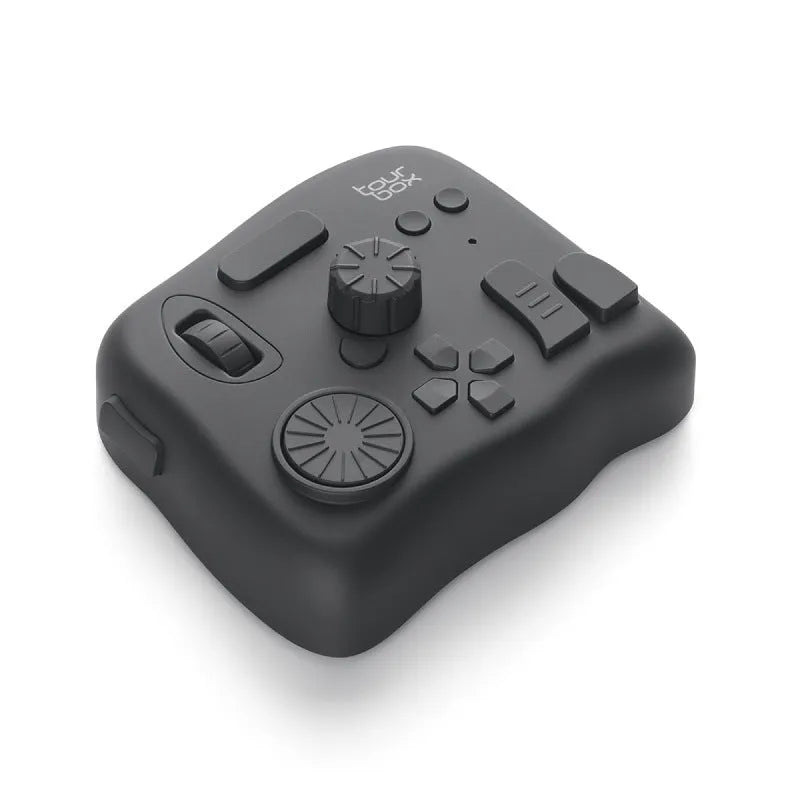 TourBox NEO black video editing controller with dials and buttons on a desk.