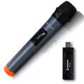 Black handheld dynamic microphone with USB receiver and cables on a table.