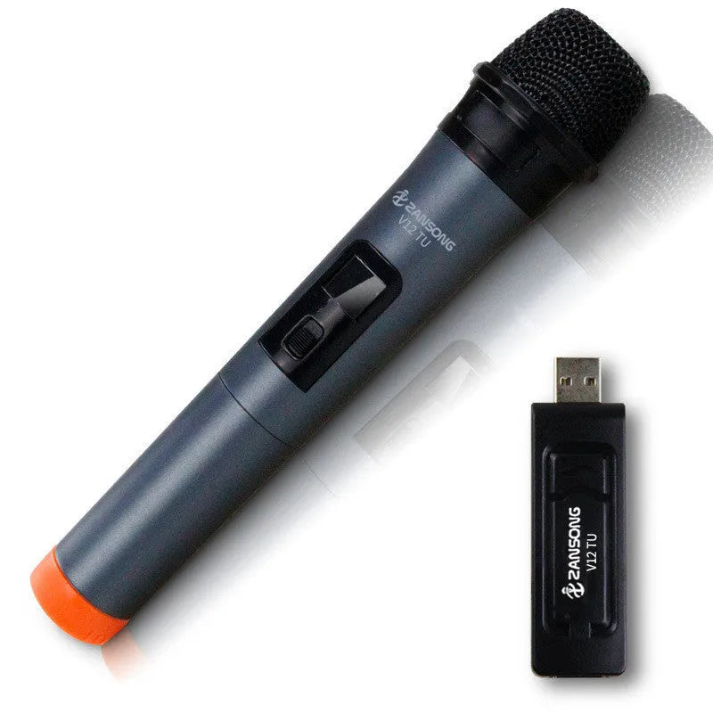 Black handheld dynamic microphone with USB receiver and cables on a table.