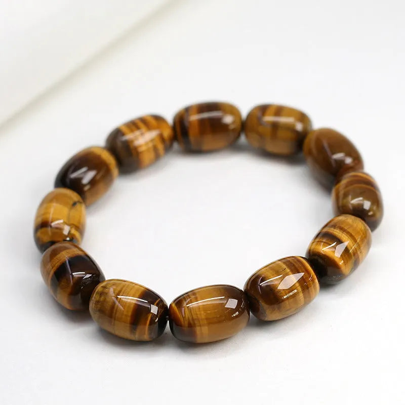 Natural yellow tigereye gemstone bracelet with ethnic constellation design on a wrist.