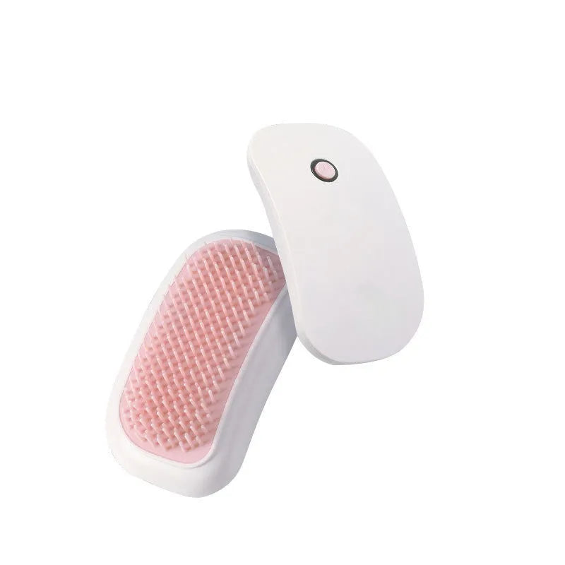 Pink handheld electric pet massage brush with soft TPE teeth on a white background.