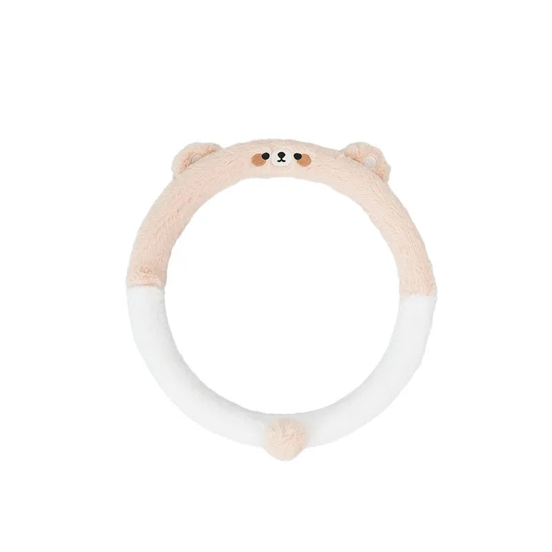 Plush steering wheel cover with embroidered bear design, shown fitted on a car steering wheel.