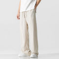 Man wearing beige straight-leg cropped bamboo fibre trousers with a drawstring waist on a summer day.
