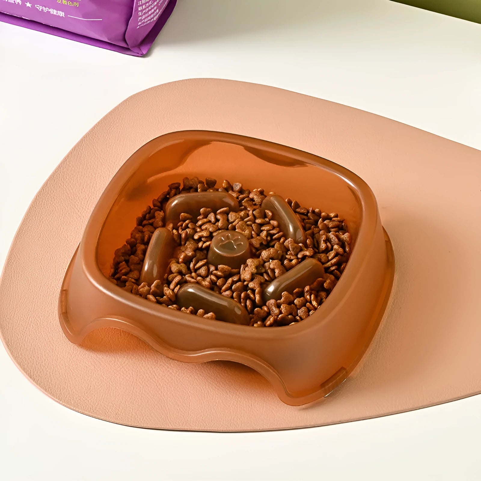 Blue plastic slow-feed dog bowl on a floor to prevent choking.