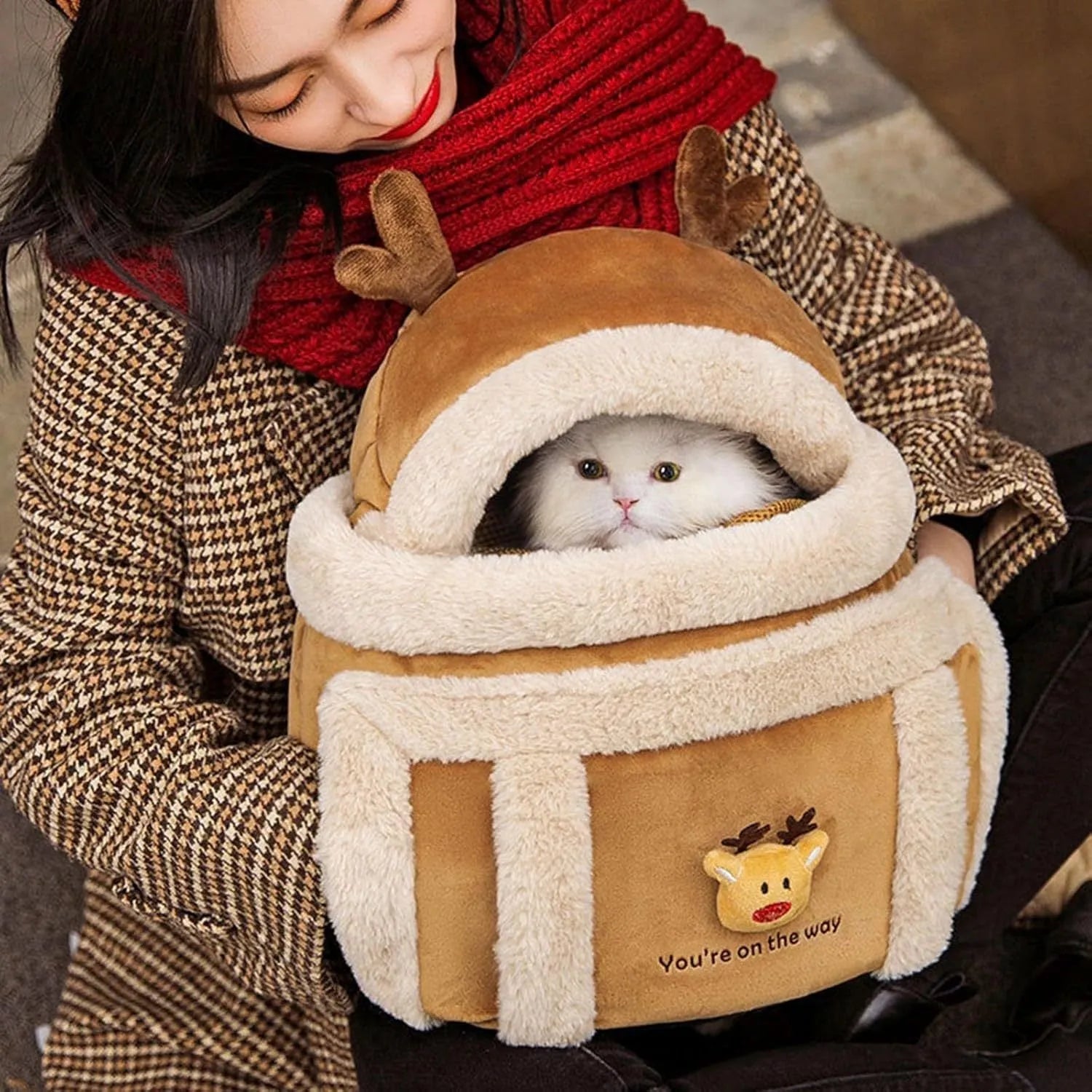 Plush reindeer pet carrier backpack with hand warmers in medium size for winter dog travel