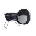 Small round metal folding stove with barbecue grill and mesh, set up for outdoor cooking.