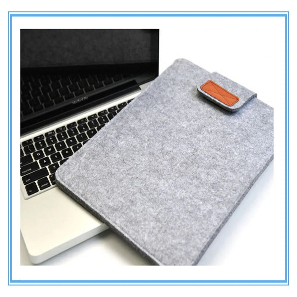 Dark grey plush felt vertical clutch laptop bag showing clamshell opening and structured interior.