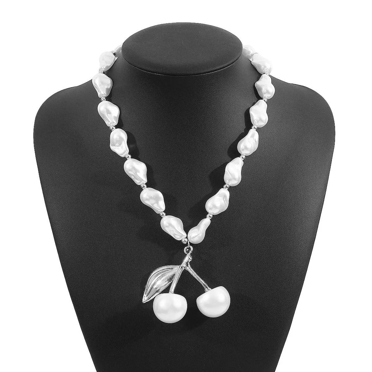 Gold-tone irregular cherry fruit pendant on an adjustable string of white imitation pearls necklace.