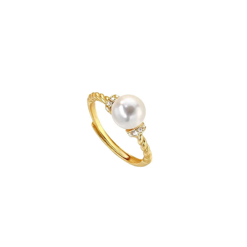 Antique-style twisted copper ring with a central white pearl, shown on a finger, adjustable band visible.