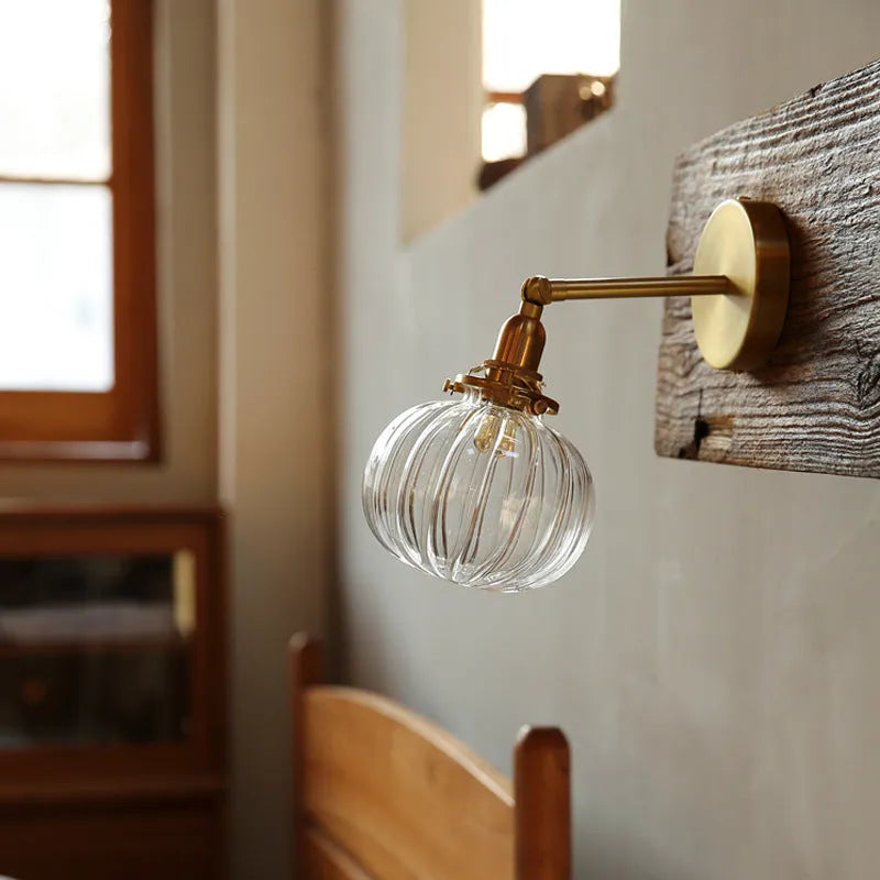 Creative pumpkin-shaped wall lamp with water ripple textured glass shade in blue, mounted on a white wall.