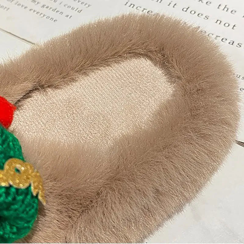 Women's festive slippers with a Christmas hat decoration on a faux plush upper.