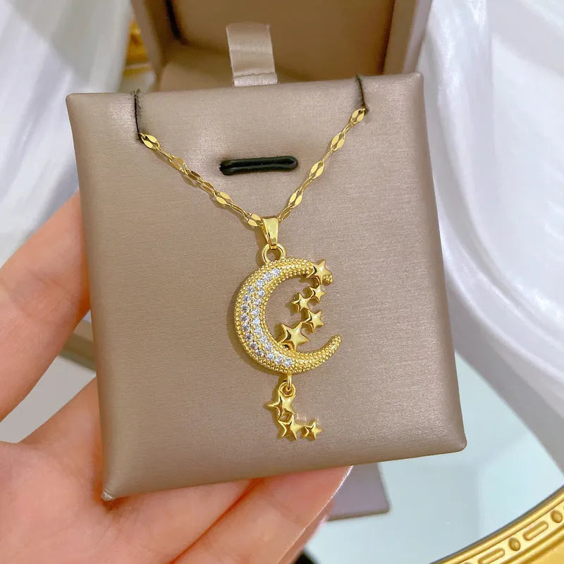 Geometric moon pendant necklace with crystals and tassel detail on an adjustable stainless steel chain.
