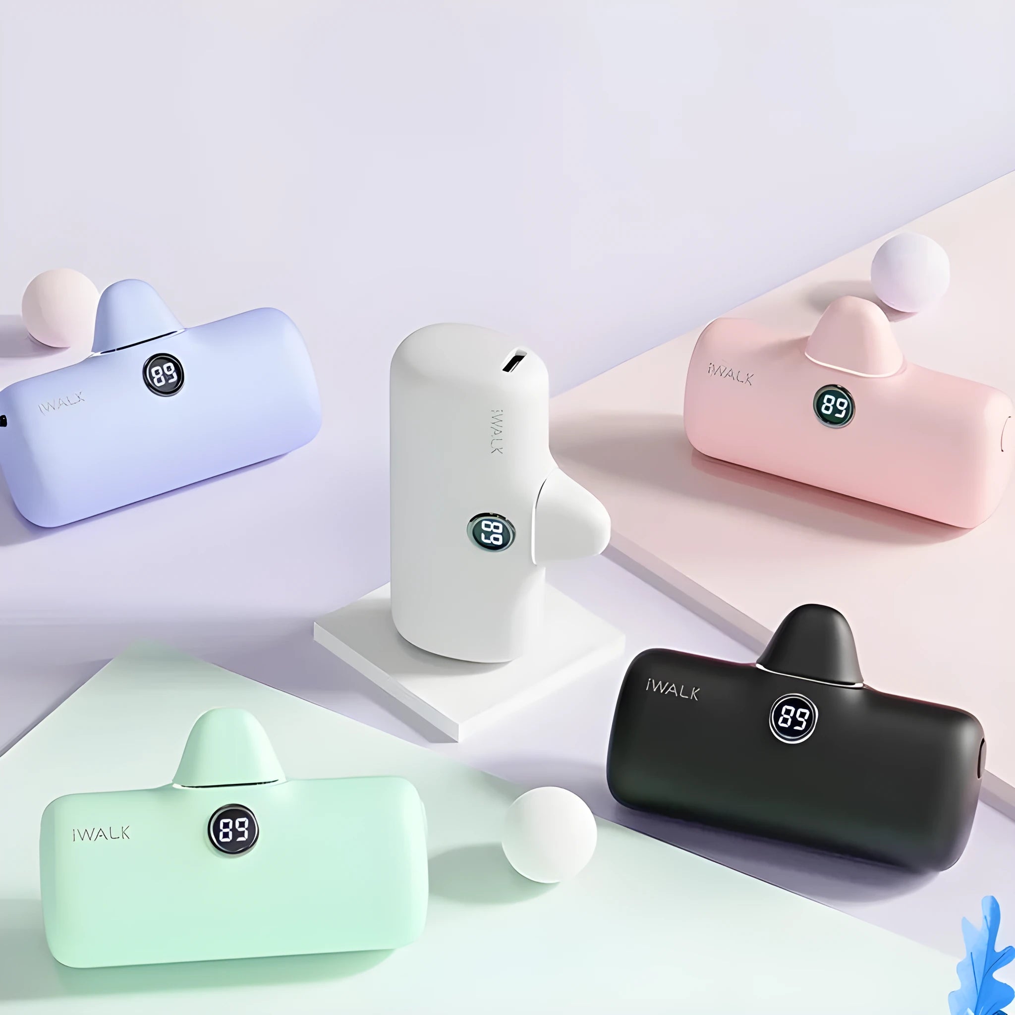 Compact white lipstick-shaped power bank with digital battery percentage display on a wooden table.