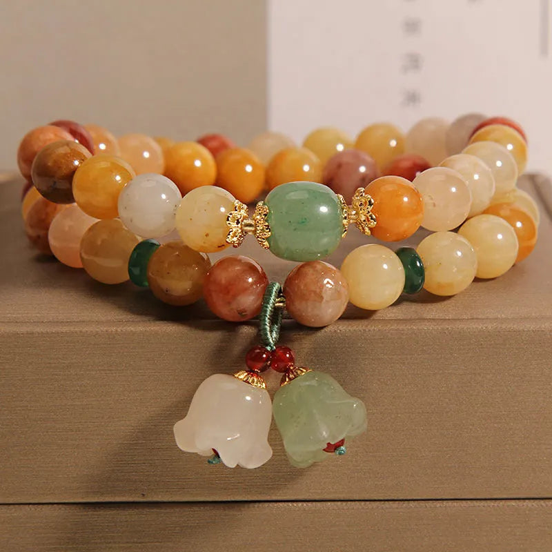 Natural jade multi-strand bracelet for women with an orchid pendant and adjustable clasp.