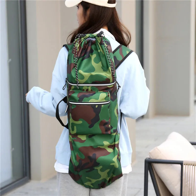 Black waterproof skateboard backpack with a longboard strapped to the side, showing padded shoulder straps.