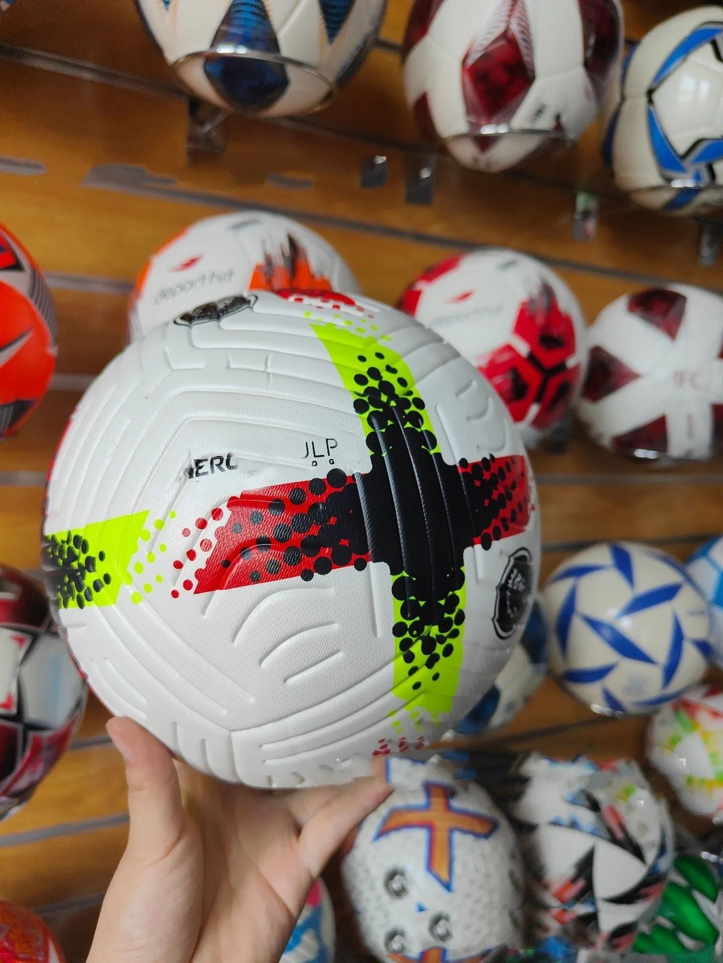 Fluorescent green Size 5 football on a field, showing seamless PU construction.