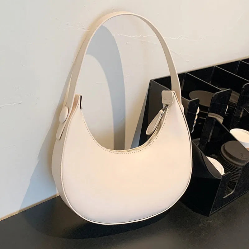Women's retro brown dumpling-shaped PU leather shoulder bag showing front and internal zipper pocket.