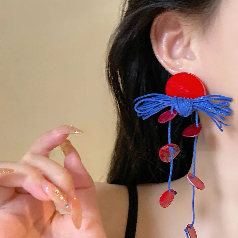 Women's geometric earrings with blue resin flower on textile base, circular shape