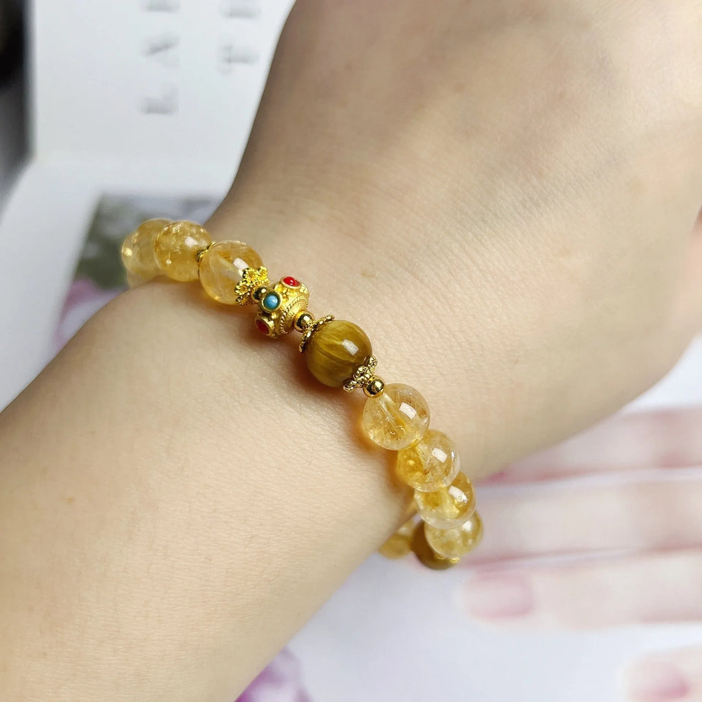 Close-up of a handcrafted citrine crystal bracelet for women with a floral tassel pendant.