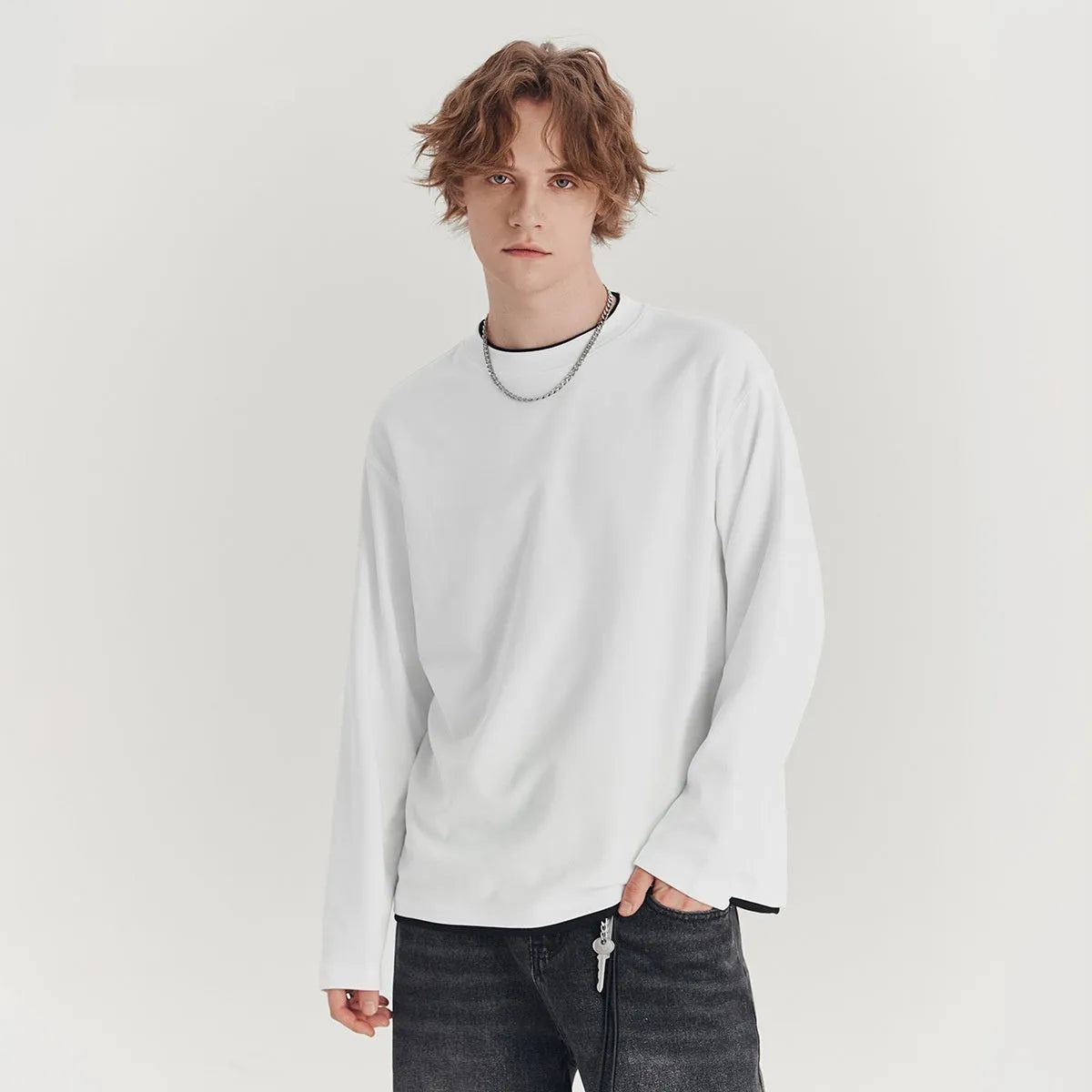 Man wearing a loose grey long-sleeved cotton blend T-shirt with a round neck.